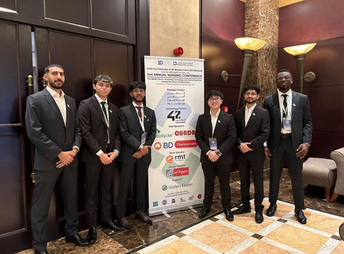 Ismail with his team beside the 2nd Annual Nursing Conference banner